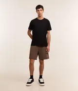 Bermuda masculina de corte slim, confeccionada en tejido de algodón con felpa. Presenta cintura elástica con cordón ajustable, bolsillos laterales y una pequeña etiqueta aplicada en el ruedo.
