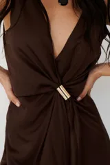 Vestido midi marrón con escote en V, sin mangas y detalle de nudo con aro dorado en la cintura.