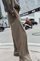 Pantalón de tiro alto con pernera recta, cintura elástica en la parte posterior y nervio marcado en el frente. Cuenta con cierre frontal de botón y ganchos, bolsillos delanteros y bolsillos de plastrón en la parte trasera.
