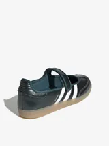 Zapatillas Adidas Samba Jane estilo Mary Jane, de color verde oscuro con las tres tiras blancas y suela de goma translúcida. Cuenta con una tira con velcro en el empeine y detalle de la inscripción 'SAMBA' en el lateral.