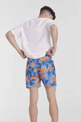 Short de baño azul con estampado de naranjas y hojas verdes.