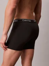 Pack de 5 bóxers tipo slip de algodón en colores negro, gris, rojo y blanco. Todos los bóxers tienen cintura elástica con el logo de Calvin Klein repetido.