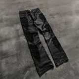 Pantalón flared negro con detalles de bordados florales en cuentas en los laterales de las piernas.