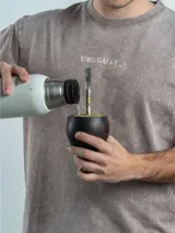 Remera de corte oversize color marrón con efecto lavado, cuello redondo y estampa frontal con la frase 'URUGUAY noma!'.