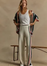 Pantalón de punto abierto de algodón orgánico color crema con rayas verticales en rojo, azul marino y verde pino. Cintura elástica acanalada con rayas de punto y silueta de pierna ancha.