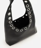 Cartera hobo de tamaño mediano, confeccionada en PU con forro de poliéster. Cuenta con asa de hombro integrada decorada con ojales metálicos plateados a lo largo de toda su estructura.