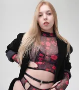 Conjunto de microtul con estampado animal print, compuesto por un top sin mangas con cuello alto y aberturas en los laterales, una tanga con tiras laterales y guantes largos sin dedos.