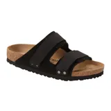 Sandalia Birkenstock modelo Uji con diseño de doble correa ajustable, confeccionada en cuero nubuck y gamuza negra. Presenta plantilla anatómica de corcho y suela de goma antideslizante.