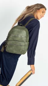 Mochila color marrón claro de símil cuero con bolsillos frontales con cierre. Tiene asa de mano rígida y correas regulables.