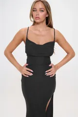 Vestido largo de fiesta confeccionado en tela lurex con acabado brillante. Presenta un diseño ajustado al cuerpo, escote recto con breteles finos y un tajo lateral pronunciado en la falda.