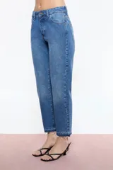 Jean recto de denim negro con tiro medio y largo al tobillo. Presenta ruedo desflecado y avíos personalizados Ginebra en níquel.