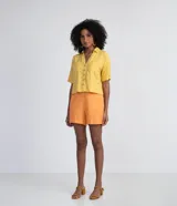 Short de tiro alto confeccionado en mezcla de viscosa y lino en color naranja. Presenta una cintura con pasadores anchos, lazo de ajuste del mismo tejido y bolsillos laterales.