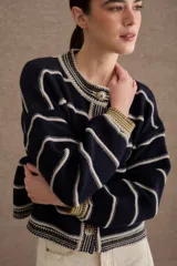 Cardigan de punto con diseño a rayas horizontales en azul marino y beige. Presenta cuello redondo, cierre frontal con botones grandes y mangas largas con puños acanalados en tono verde oliva. Incluye un pequeño bordado de una raqueta de tenis en el lateral.