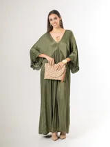 Vestido largo de satén italiano color verde militar, con escote en V profundo, corte oversized de caída amplia y fluida, y mangas tres cuartos con detalles de volados en los puños.