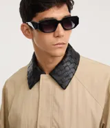 Campera de sarga color beige con corte oversized, cuello de cuero sintético negro con textura trenzada, cierre frontal oculto y bolsillos laterales.