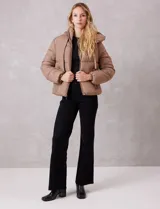 Campera puffer de corte recto y acabado mate, con diseño de bloques horizontales acolchados. Presenta capucha integrada con cordones de ajuste, cierre frontal metálico y bolsillos laterales invisibles. Incluye puños elásticos internos para mayor protección contra el frío.