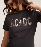 Remera de manga corta y cuello redondo, color gris oscuro, con estampado frontal del logo de la banda AC/DC con efecto metalizado o desgastado.