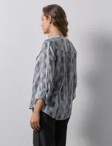 Blusa de gasa estampada multicolor, marca Ruby Rd. Tiene cuello a la base, escote en V, abertura central con botones y plisados en la parte delantera. Las mangas son 3/4 y tienen un largo regulable con presilla y botón.