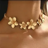 Gargantilla tipo choker dorada con cinco flores tridimensionales de metal con pétalos texturizados.