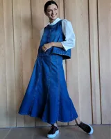 Pollera midi de denim azul con corte acampanado y costuras verticales decorativas que aportan estructura y movimiento.