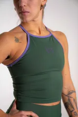 Musculosa deportiva verde oscuro de lycra con doble tela, cuello halter con ribete lila, y logo estampado en el pecho.