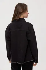 Sobrecamisa de denim negro con calce relajado, mangas largas, cuello clásico, cierre frontal con botones y bolsillo aplicado. Cuenta con detalles de strass en toda la prenda y terminación desflecada en el bajo.