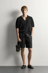 Bermuda de lino negro de corte relaxed fit, con cintura elástica ajustable mediante cordón y bolsillos frontales.