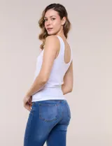 Musculosa básica blanca de punto elastizado, con escote redondo pronunciado al frente y en la espalda, sin mangas y con breteles anchos.