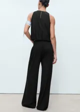 Pantalón largo negro de corte recto y tiro medio, con cintura elástica y bolsillos laterales. Confeccionado en tejido de punto fino con mezcla de viscosa.