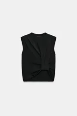 Top de punto negro con cuello redondo, manga sisa, hombreras y detalle de pliegues en la parte delantera.