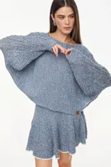 Sweater cropped de punto calado, color celeste melange, con mangas anchas de diseño holgado y cuello redondo.