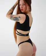 Pantie colaless negro con estampado de pequeñas flores blancas y tiras finas con aros metálicos.