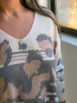 Sweater de punto con cuello en V, diseño holgado y estampado animal print con detalles en dorado.