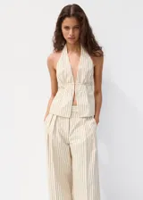 Top halter de color beige con rayas finas, escote en V pronunciado, diseño sin mangas y cintura fruncida con ajuste delantero.