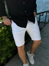 Bermuda de jean blanco con corte skinny, confeccionada en denim con lycra. Presenta un diseño clásico de cinco bolsillos y cierre frontal con botón y cremallera.