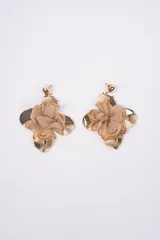 Aros colgantes con diseño floral, compuestos por pétalos metálicos dorados y una flor central de tela blanca semitransparente.