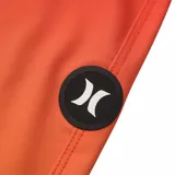 Short de baño Hurley con diseño en degradado de color naranja a rojo, con tres franjas blancas horizontales en la pierna izquierda y cordón ajustable en la cintura.