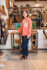 Sobre camisa coral de manga larga, con canesú en la espalda y detalles en los puños de tela estampada con flores.