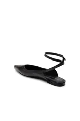 Zapato plano negro de cuero, tipo chatita, con punta fina y tiras con hebilla ajustable alrededor del tobillo.