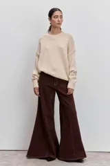 Jeans acampanados de tiro alto, color marrón oscuro, con costuras decorativas en contraste.