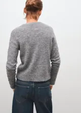 Jersey de punto liso color gris, con cuello redondo y diseño recto de manga larga.