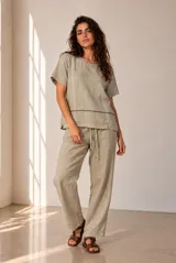 Blusa de lino color beige, de manga corta y cuello redondo, con detalles de bordados geométricos en contraste.