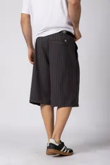 Bermuda sastrera baggy de color negro con diseño de rayas diplomáticas finas blancas. Cuenta con bolsillos laterales y presillas para cinturón.