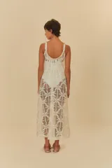 Vestido largo de tela artesanal color blanco con diseño de palmeras, de corte holgado, tirantes finos y escote redondo.