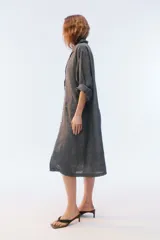 Tapado oversize largo midi, color gris con textura de microcuadrillé, cuello con solapa, cierre frontal con botones, bolsillos con tapa y hombros caídos.