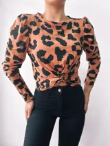 Remera color camel con estampado animal print negro, de mangas largas abullonadas y nudo en la parte delantera.