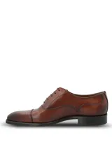 Zapato de vestir tipo Oxford en cuero color marrón, con puntera reforzada y cierre mediante cordones. Presenta un diseño clásico con suela mixta de cuero y goma.