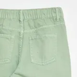 Pantalón de corte wide leg en color verde menta, con cintura elástica y cierre frontal con botón metálico. Presenta bolsillos laterales y diseño de tiro medio.