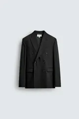 Blazer de corte regular confeccionada en tejido de lana italiana. Presenta cuello con solapas de pico, cierre frontal de botonadura cruzada, manga larga con puños abotonados, bolsillos de vivo en el pecho y bolsillos de solapa en la cadera.