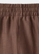 Pantalón palazzo marrón de tiro medio, con cintura elástica ajustable, bolsillos laterales y diseño largo de pernera ancha.